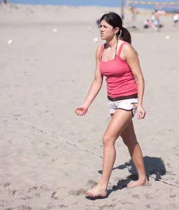 Hot girls playing beach volleyball in bikinis and shorts