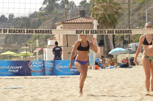 Sexy beach volleyball girl in sport bra top with pokies and blue bikini bottom