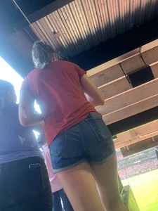 Bunch of girls in various outfits at a Cardinals baseball game