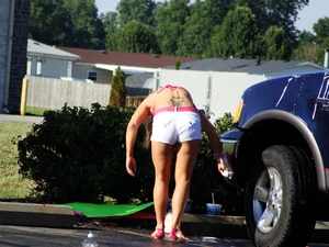 Group of cute girls at a car wash in bikinis and shorts