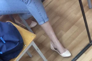 Skinny Legs of a College Teen in Blue Jeans And Flats in Class