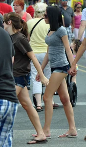 Skinny brunette in tiny denim shorts showing a little cheek