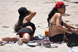 Beach girl can't keep her tits in her bikini