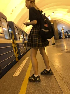 Skinny Teen in a Chequered Skirt With a Backpack in a Subway