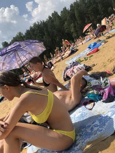 Skinny Teen in a Yellow Swimsuit Sitting on a Beach Gallery