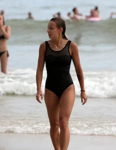Skinny sexy lady on the beach in a black swimsuit
