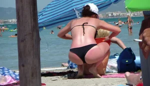 Amazing ass in semi-thong bikini on the beach with tanlines