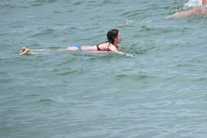 Skinny and sexy brunette on the beach in black and blue bikini