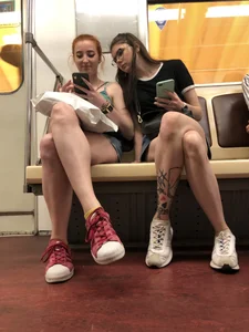 Two Girls With Hot Long Legs in Mini Shorts and Sneakers in the Subway Train Candid Photo Gallery