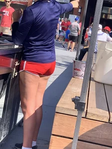 Bunch of girls in various outfits at a Cardinals baseball game