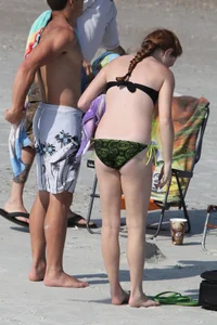 Pale redhead teen in bikini on the beach