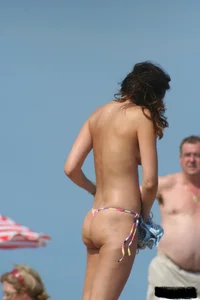 2 topless girls at the beach in thongs