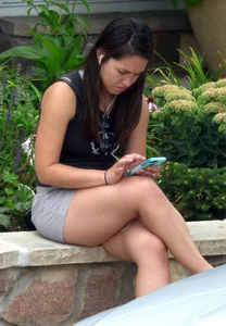 Thick brunette listening to music in shorts