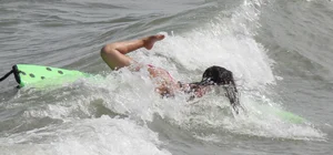 Brunette bikini girl on the beach and surfing in her bikini