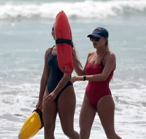 Two sexy lifeguards in red and blue swimsuits