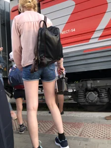Candid with long thin legs wearing denim shorts waiting to get on a train