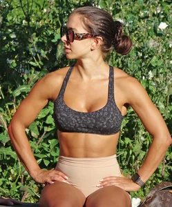 Tanned fitness woman showing off her toned physique & amazing butt