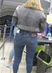 Two hot milfs in tight blue jeans standing at the cash register at the supermarket, awesome big butts