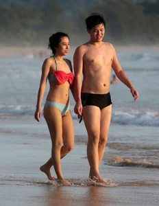 Cute Asian in bikini on the beach with her boyfriend