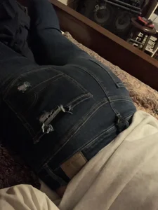 Teen booty in jeans lying on the floor closeup