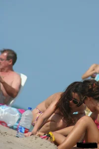 2 topless girls at the beach in thongs