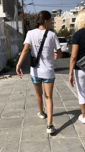 Cute skinny teen in shorts walking down the street