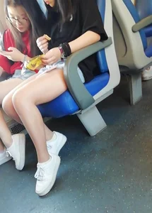 Two cute Asian teens on the bus in shorts showing their legs