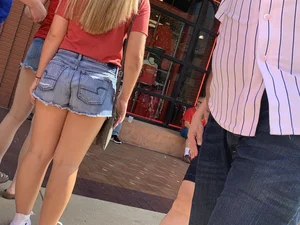 Bunch of girls in various outfits at a Cardinals baseball game
