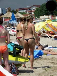 Topless blonde babe on the beach with a big booty in a black thong