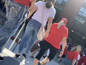 Bunch of girls in various outfits at a Cardinals baseball game