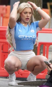Curvy blonde girl in soccer / football kit & shorts poses for photos
