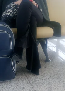 Girl in Pants And High-Heeled Shoes Sitting at the Station With Crossed Legs