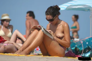 2 topless girls at the beach in thongs
