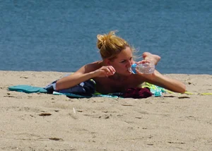 Sexy ass blonde milf on the beach in a thong with cameltoe and bending over