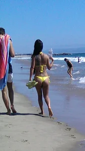 Beach babe with a nice ass and big tits in yellow thong bikini