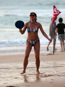 Older lady playing on the beach in her bikini