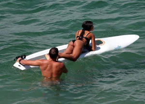 Black girl on the beach in a bikini with an incredible ass while surfing