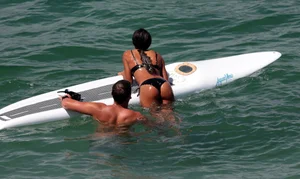 Black girl on the beach in a bikini with an incredible ass while surfing