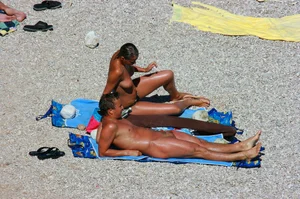 Nudist couple on the beach, girl has amazing tits and nice ass in a thong