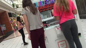 Little blonde teen in grey leggings at the mall with her friends