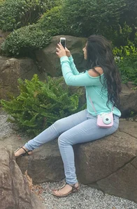 Girl in Jeans And Sandals Taking a Selfie in a Park