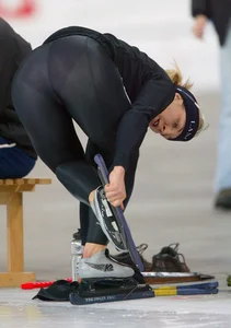 Female Athlete in Seethrough Tights Bending Over to Fix Her Skates Photo