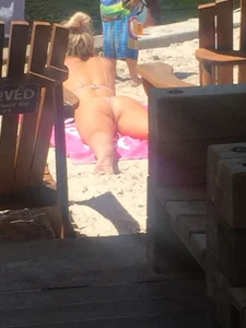 Milf in Swimsuit Lying on Her Stomach at the Beach With Spread Legs