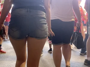 Bunch of girls in various outfits at a Cardinals baseball game