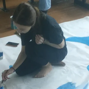Skinny teen painting on the floor