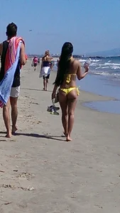 Beach babe with a nice ass and big tits in yellow thong bikini