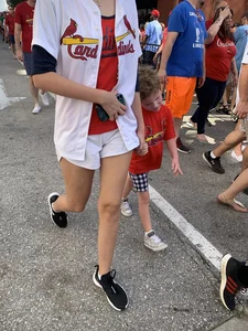 Bunch of girls in various outfits at a Cardinals baseball game