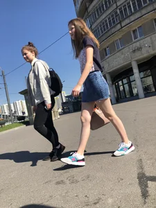 Cute Girl in a Short Denim Skirt Walking on a Street And Waiting on a Crosswalk Gallery