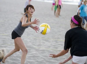 Hot girls playing beach volleyball in bikinis and shorts