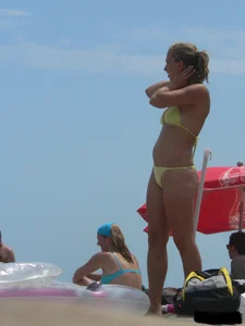 Sexy blonde on the beach in a yellow thong bikini